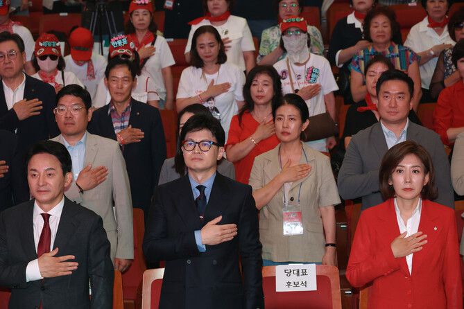 국민의힘 7·23 전당대회 당대표 선거에 출마한 원희룡·한동훈·나경원(왼쪽부터) 후보가 지난 10일 부산 벡스코에서 열린 부산·울산·경남 합동연설회에서 국기에 경례하고 있다. 연합뉴스