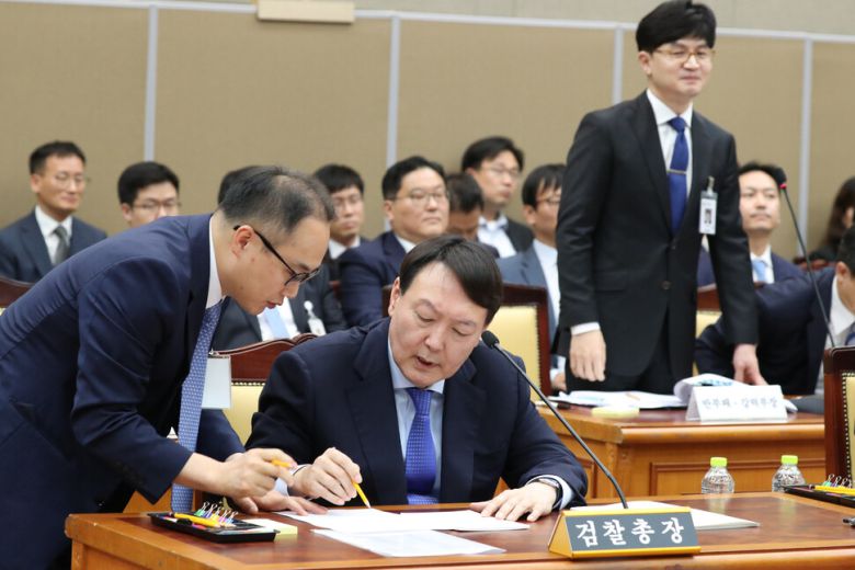 2019년 10월17일 윤석열 검찰총장이 국회 대검찰청 국정감사에서 이원석 대검 기획조정부장의 도움을 받아 자료를 검토하고 있다. 한동훈 대검 반부패·강력부장이 오른쪽에서 웃으며 지켜보고 있다.강창광 선임기자 chang@hani.co.kr