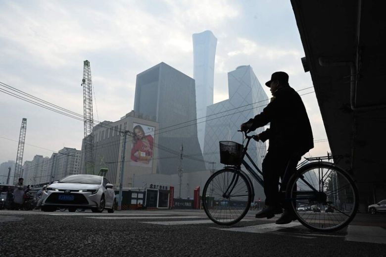 10일 중국 베이징 중심가에서 한 남성이 자전거를 타고가고 있다. 베이징/AFP 연합뉴스