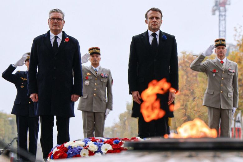 에마뉘엘 마크롱 프랑스 대통령(오른쪽)과 키어 스타머 영국 총리가 11일 파리 샤를드골 광장(에투알 광장)에 마련된 무명용사의 무덤 앞에 서서 묵념을 하고 있다. 파리/AFP 연합뉴스