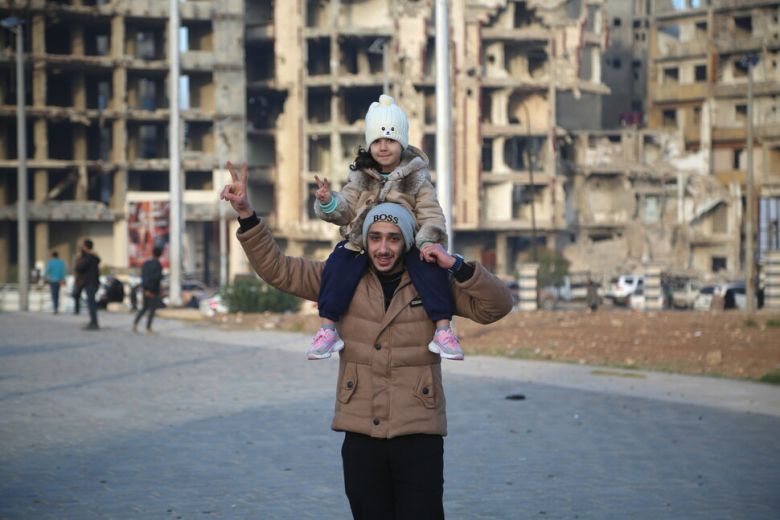 8일 시리아 도시 홈스에서 어린이를 어깨에 태운 시민이 반군의 수도 다마스쿠스 점령 소식에 기뻐하는 몸짓을 하고 있다. 홈스/EPA 연합뉴스