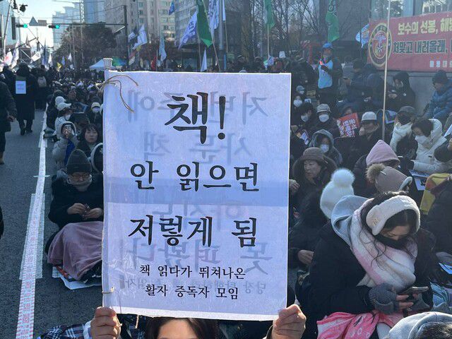 14일 오전 서울 여의도 국회 앞에서 ‘책 읽다가 뛰쳐나온 활자 중독자 모임’ 깃발 아래 모인 시민들이 독서를 하며 탄핵안 가결을 기다리고 있다. 임재희 기자 limj@hani.co.kr