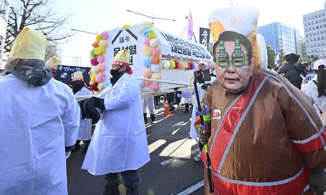 12·3 내란사태를 일으킨 내란죄 피의자 윤석열 대통령에 대한 탄핵소추안 2차 표결을 앞둔 14일 오후 서울 여의도 국회 앞에서 윤석열 정권을 상징하는 관을 든 시민들이 행진하고 있다. 최성열 씨네21 기자 youl@cine21.com