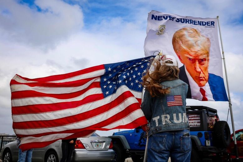 2024년 12월 14일, 미국 대통령 당선인 도널드 트럼프의 별장이 있는 플로리다주 마러라고 리조트 근처에서 트럼프 지지자들이 미국 국기와 트럼프 사진 깃발을 흔들고 있다. AFP 연합뉴스