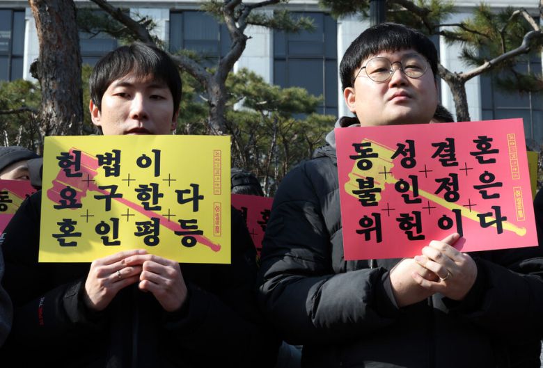 혼인평등 헌법소원 기자회견이 14일 오전 서울 종로구 헌법재판소 앞에서 열려 지난해 7월 대법원으로부터 건강보험 피부양자 자격을 인정받은 동성부부 소성욱(오른쪽)씨와 김용민씨가 손팻말을 들고 있다. 김태형 기자