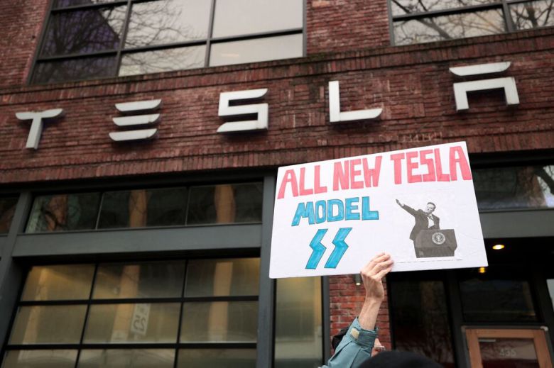 지난 15일(현지시각) 미국 워싱턴 시애틀의 테슬라 매장 앞에서 시위 중인 시민. 로이터 연합뉴스