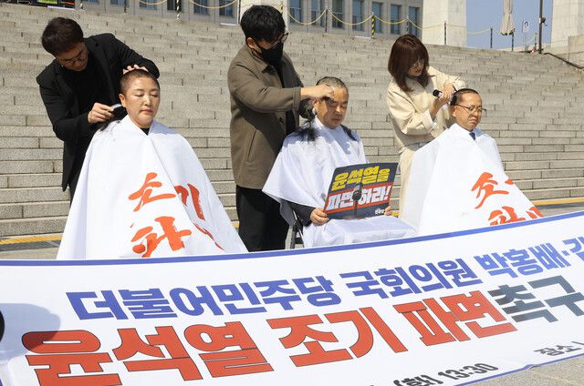 더불어민주당의 전진숙·박홍배·김문수(왼쪽부터) 의원이 11일 서울 여의도 국회 본관 계단 앞에서 윤석열 대통령의 조기파면을 촉구하며 삭발을 하고 있다. 윤운식 선임기자 yws@hani.co.kr