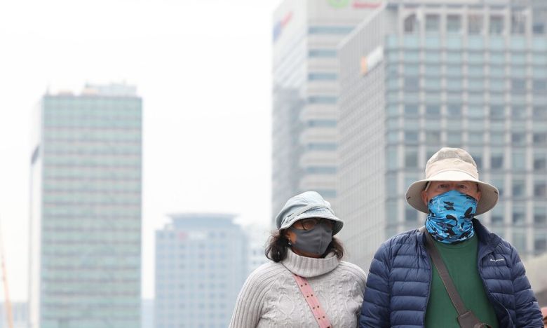 미세먼지에 황사까지 유입된 12일 서을 종로구 광화문광장 인근에서 외국인 관광객이 마스크를 쓰고 이동하고 있다. 연합뉴스