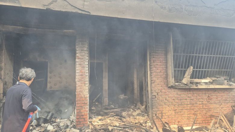 26일 경북 영덕군 영덕읍 매정1리 들머리에 불 탄 집에 이웃주민이 물을 뿌리고 있다. 주성미 기자