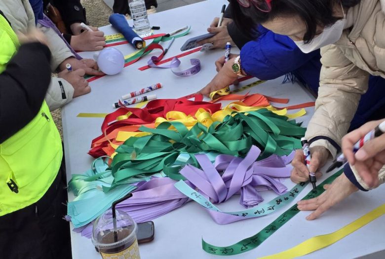 1일 광화문 동십자각에서 열린 윤석열즉각퇴진·사회대개혁 비상행동(비상행동) 집회 참가자들이 헌법재판소에 전할 말을 리본에 적고 있다. 참가자들은 이를 헌재 인근에 달아둘 예정이다. 김가윤 기자