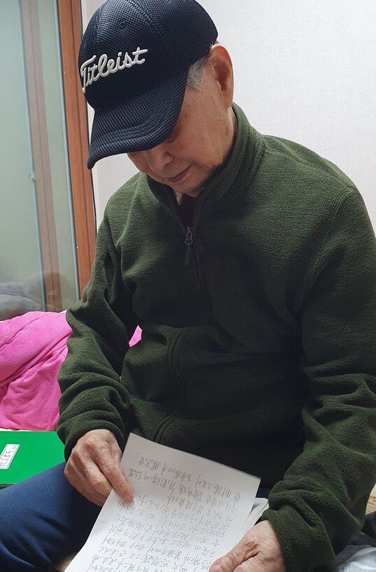 김양학씨가 자신이 쓴 ‘토산리 실상기’를 보고 있다. 허호준 기자