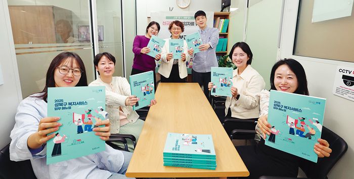 성북구 생활보장과 직원들이 자체적으로 제작한 2025년 복지서비스 업무 매뉴얼을 들고 있다. 왼쪽부터 문지민·이현지·최진희씨, 김경임 과장, 우정권·최윤경씨, 오지은 팀장. 성북구 제공