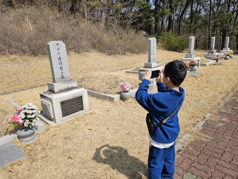보훈둘레길의 주황길 중간쯤 있는 국가사회공헌자 묘역 가장 위쪽에 안장된 손기정 선수의 묘소 모습을 아이가 휴대전화 카메라로 찍고 있다. 최예린 기자