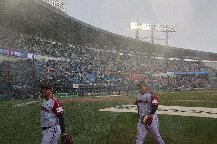 13일 서울 잠실야구장에서 열린 프로야구 두산 베어스와 엘지(LG) 트윈스의 경기 중 갑자기 내린 눈으로 경기가 잠시 중단되고 있다. 연합뉴스