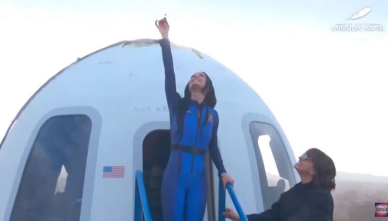 캡슐에서 나온 팝스타 케이티 페리가 우주를 향해 데이지꽃을 들어보이고 있다. 웹방송 갈무리