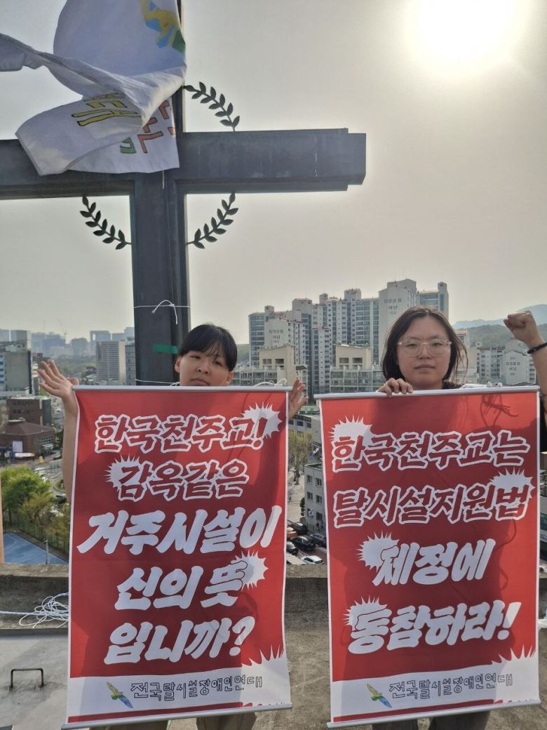 전국장애인차별철폐연대(전장연) 등 장애인단체 활동가들이 18일 서울 종로구 혜화동성당 종탑에서 ‘탈시설’을 반대하는 천주교에 항의하는 고공농성에 돌입했다. 전장연 제공