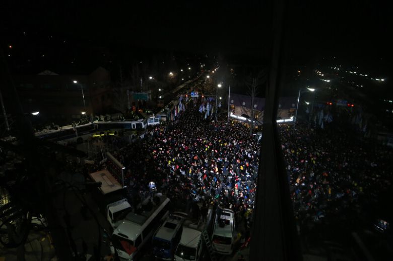 ‘박근혜 즉각 퇴진 6차 촛불집회’가 열린 2016년 12월3일 저녁 서울 종로구 청운효자동주민센터 앞 신교동교차로에 모인 시민들이 저녁 7시가 되자 ‘저항의 1분 소등’에 동참해 촛불을 모두 끈 채 앉아 있는 동안 생방송 중계를 위한 조명이 들어와 있다. 김정효 기자 hyopd@hani.co.kr