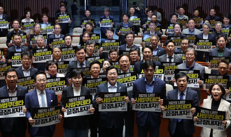 더불어민주당 박찬대 원내대표를 비롯한 의원들이 4일 국회에서 열린 긴급 의원총회에서 대법원 규탄 팻말을 들고 구호를 외치고 있다. 연합뉴스