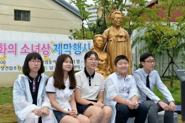 지난 2017년 8월12일 광주광역시 남구 펭귄마을 들머리에 있는 평화의 소녀상 앞에서 학생들이 사진을 찍고 있다. 남구 제공