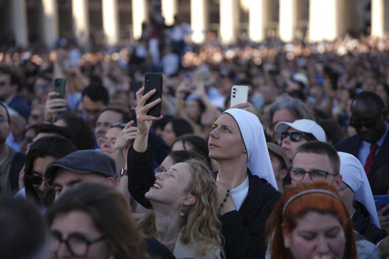 지난 8일(현지시각) 바티칸 시스티나 경당(성당)의 굴뚝에서 새 교황이 선출됐음을 알리는 흰 연기가 피어오르자 신자와 시민들이 환호하며 사진을 찍고 있다. AP 연합뉴스