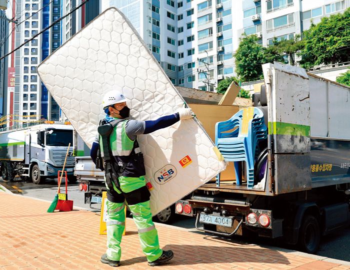 입는 로봇을 착용한 환경공무관이 무거운 매트리스를 들어올리고 있다. 도봉구 제공