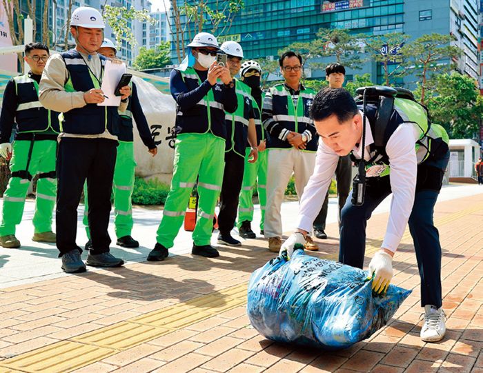 입는 로봇을 착용한 오언석 구청장이 폐기물 봉투를 들어보고 있다. 도봉구 제공