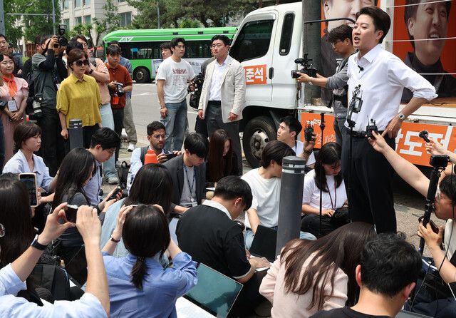 서울 영등포구 여의도공원에서 28일 열린 이준석 개혁신당 대통령 후보 유세 현장에서 한 여성(노란 옷)이 지난 밤 대선 후보 토론회에서 이 후보의 발언에 대해 항의하고 있다. 백소아 기자 thanks@hani.co.kr