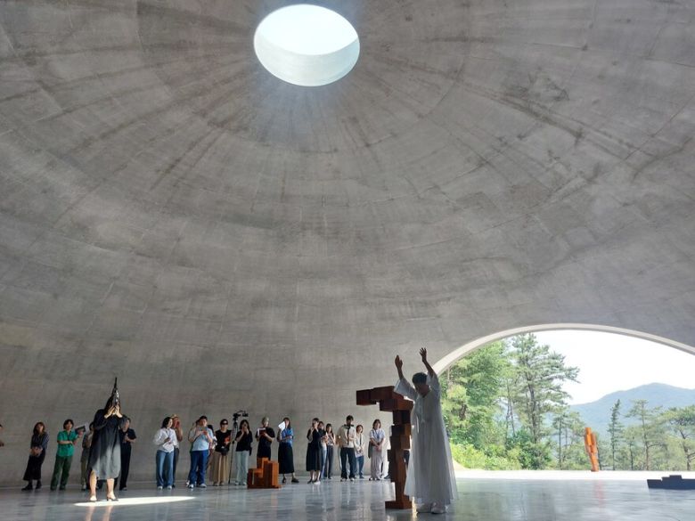 19일 오전 원주 뮤지엄 산 경내에서 공개된 앤터니 곰리와 안도 다다오의 협업 작품공간 ‘그라운드’의 공연 현장. 원로 춤꾼 홍신자씨(가운데 흰옷 입은 사람)와 생황 연주자 김효영씨(왼쪽 악기 부는 사람)가 앤터니 곰리의 조형물을 사이에 두고 퍼포먼스를 벌이고 있다. 오른쪽 트인 출구로는 원주의 드넓은 산야가 눈에 들어온다. 노형석 기자