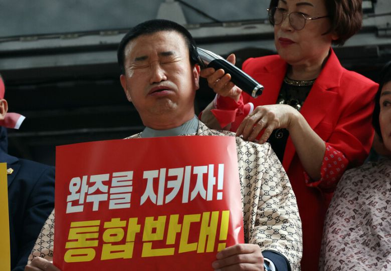 김관영 전북자치도지사의 완주군 방문이 예정된 25일 완주군청사 앞에 설치한 무대에서 유의식 완주군의회 의장을 비롯한 의원 10명이 전주·완주 통합을 반대하며 삭발하고 있다. 연합뉴스