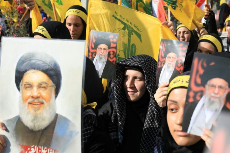 25일(현지시각) 레바논 베이루트 남부 교외 이란 대사관 밖에서 이스라엘과 이란 간의 휴전을 기념하기 위한 집회에서 레바논 무장정파 헤즈볼라의 깃발을 든 지지자들이 이스라엘에 의해 살해된 헤즈볼라 지도자 하산 나스랄라(왼쪽)와 이란 최고 지도자 아야톨라 알리 하메네이(오른쪽)의 사진을 들고 있다. 테헤란/AFP 연합뉴스