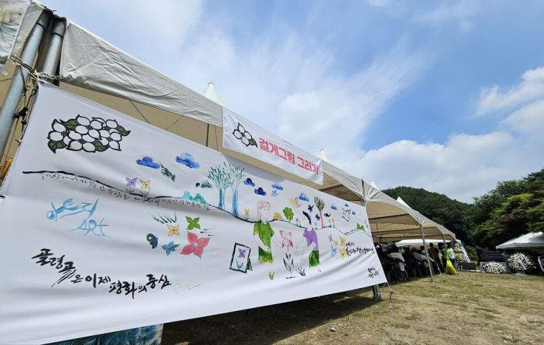 27일 오전 ‘산내골령골학살희생자 합동위령제’가 진행된 대전 동구 낭월동 골령골에 전날 이곳에서 열린 ‘골령골 평화예술제’에 참여한 시민들이 함께 걸게그림이 전시돼 있다. 최예린 기자