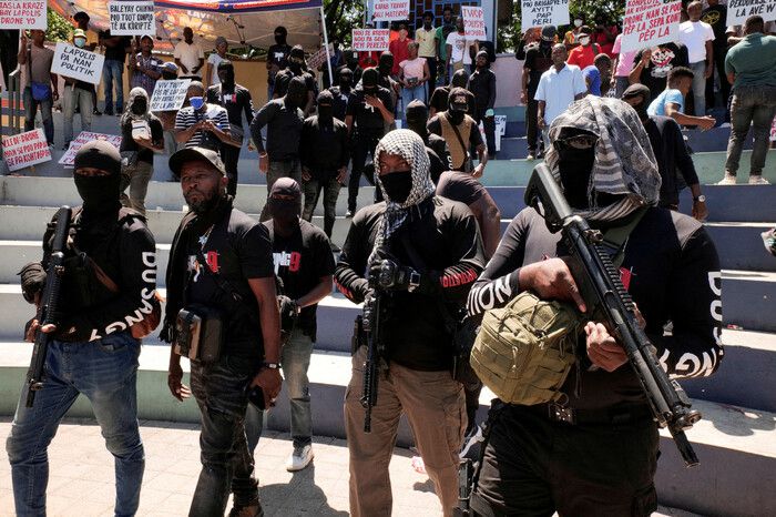 지난달 28일 아이티 수도 포르토프랭스에서 시민들이 시위하고 있는 가운데 총을 들고 있는 전직 경찰관 ‘사무엘 사령관’이 이끄는 ‘두상 9’ 갱단 소속 무장대원들의 모습. 로이터 연합뉴스