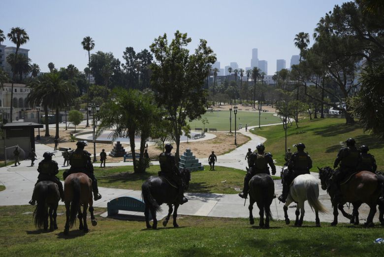 중무장한 연방 요원들이 말을 타고 7일(현지시각) 미국 캘리포니아주 로스앤젤레스시 맥아더 공원에서 미등록 이민자 단속 활동을 하고 있다. AP 연합뉴스