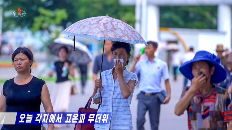 북한이 지난 8일부터 무더위 주의경보를 발령한 가운데 평양 시내에서 시민들이 양산을 쓰고 거리를 걸어가고 있다. 조선중앙티브이(TV) 화면 갈무리