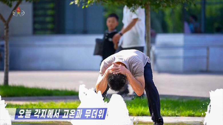 무더위가 지속되는 북한 평양에서 한 남성이 분수대에 고개를 숙이고 머리에 물을 뿌리며 더위를 식히고 있다. 조선중앙티브이(TV) 화면 갈무리