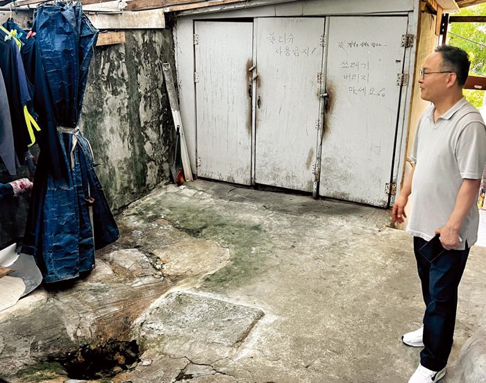 쪽방 주민들이 공동으로 사용하는 수돗가와 화장실을 전익형 서울역쪽방상담소 실장이 둘러보고 있다.