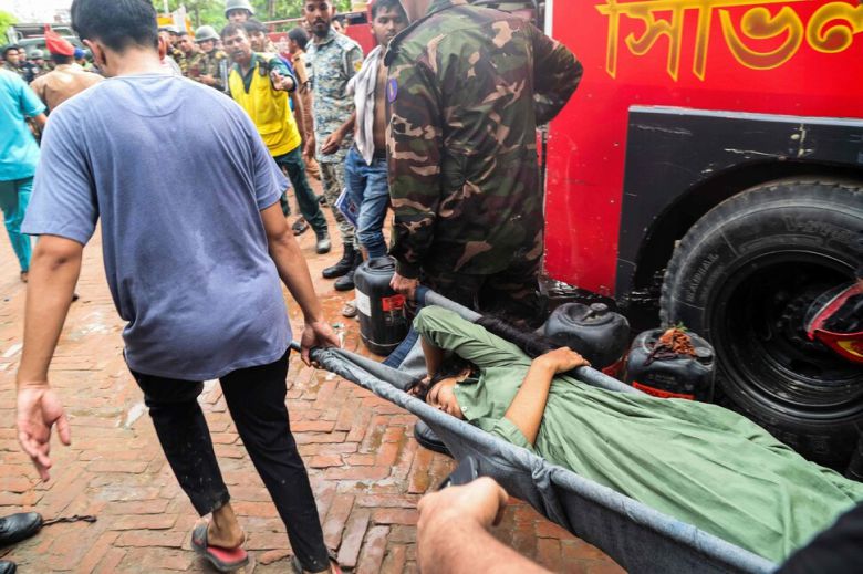 21일 방글라데시 다카에서 공군 훈련기가 학교에 추락한 뒤, 구조대가 부상자를 구급차로 옮기고 있다. AFP연합뉴스