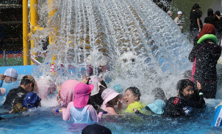 전국적으로 폭염이 이어진 27일 오후 서울 성북구 숭덕초등학교에 마련된 성북문화바캉스 물놀이장을 찾은 어린이와 시민들이 떨어지는 물을 맞으며 즐거워 하고 있다. 김태형 기자 xogud555@hani.co.kr
