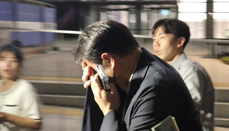 김건희 여사 오빠인 김진우씨가 28일 밤 김 여사 관련 의혹들을 수사하는 민중기 특별검사팀 사무실이 위치한 서울 종로구 케이티(KT)광화문빌딩웨스트(West)에서 조사를 마친 뒤 얼굴을 가린 채 특검 사무실을 나서고 있다. 연합뉴스