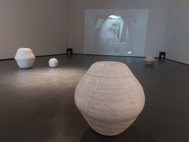 대구 우손갤러리 2층 전시장. 코로나 팬데믹 시기 고립된 도시 공간의 기억을 담은 이승애 작가의 흑연 드로잉 영상물이 안쪽 벽면에 투사되고, 그 앞에는 옛 달항아리를 다양한 재질의 흰빛 점토들을 섞어 낯선 덩어리들로 재해석한 문이삭 작가의 ‘흰달’ 연작들이 놓였다. 노형석 기자