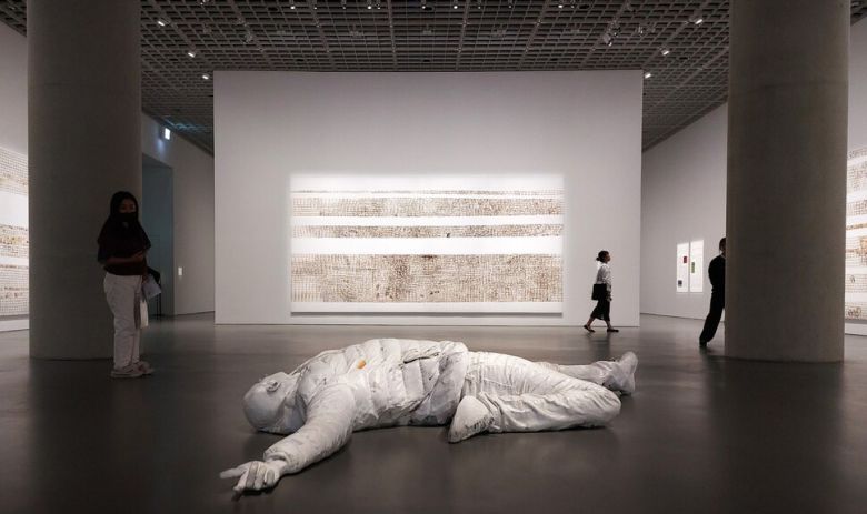 두번째 전시실 바닥에서 만나게 되는 조형물 ‘데스 드롭’(Death Drop, 2023). 패딩 재킷을 입은 인물이 두 팔을 한껏 벌리고 오른 다리를 꺾은 채 바닥에 누운 모습을 형상화한 이 작품은 어린 시절 작가 자신이 넘어진 순간을 포착한 영상을 바탕으로 뉴욕 퀴어클럽의 데스 드롭이란 춤 동작을 결합시킨 도상이라고 한다. 죽음과 자유, 몸의 역동성과 유약함, 환희와 공포 등의 엇갈리는 감정과 상상을 떠올리게 한다. 조형물 뒤쪽 정면과 옆으로는 미용실에서 쓰는 파마 조발용 격자 종이 ‘엔드 페이퍼’를 줄지어 붙인 특유의 추상회화 연작들이 내걸려 있다. 노형석 기자