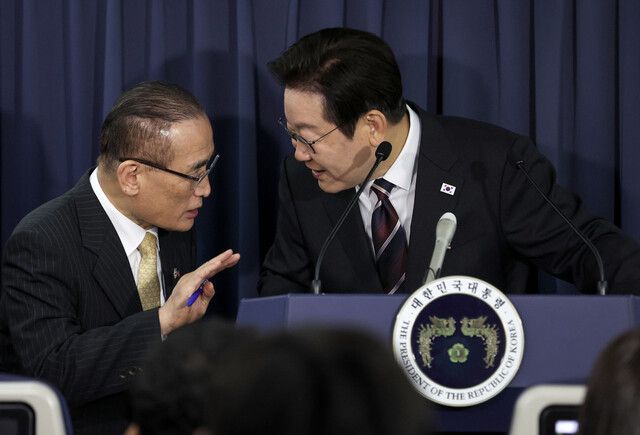 이재명 대통령과 위성락 국가안보실장이 24일(현지시각) 일본 도쿄 하네다공항 이륙 뒤 한미 정상회담을 위해 미국 워싱턴으로 향하는 공군 1호기 기내에서 기자간담회를 하며 논의하고 있다. 연합뉴스