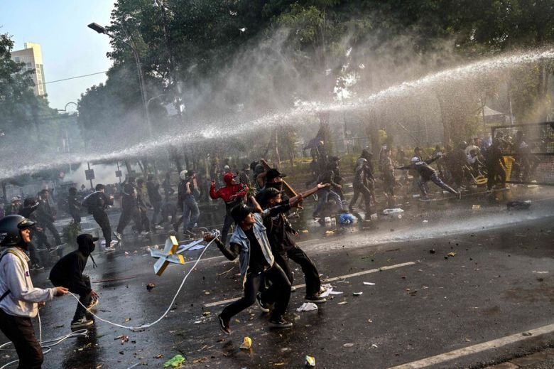 29일, 인도네시아 수라비야에 있는 동자바 주지사 관저 앞에서 오토바이 배달기사 사망 사건에 항의하는 시위대를 향해 경찰이 물대포를 쏘고 있다. 수라바야/AFP 연합뉴스