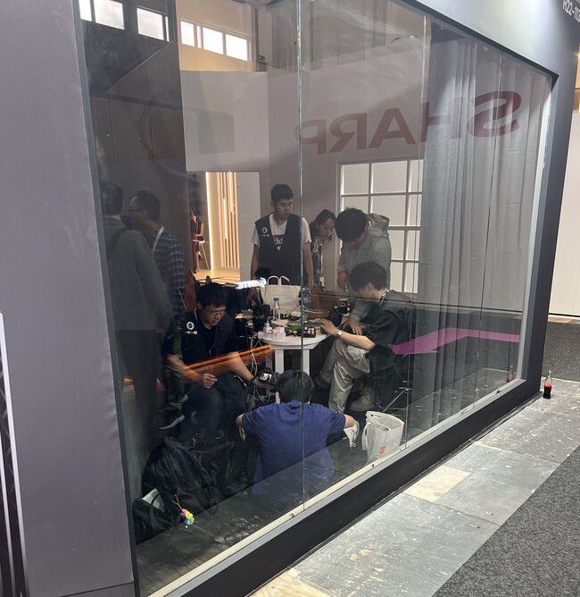 지난 5일(현지시각) 독일 베를린 국제 가전 전시회(IFA)의 레이저 프로젝터 분야 신생 기업인 ‘발레리온’ 전시관 뒤쪽에서 중국 청년들이 도시락을 먹으며 일하고 있다. 박종오 기자