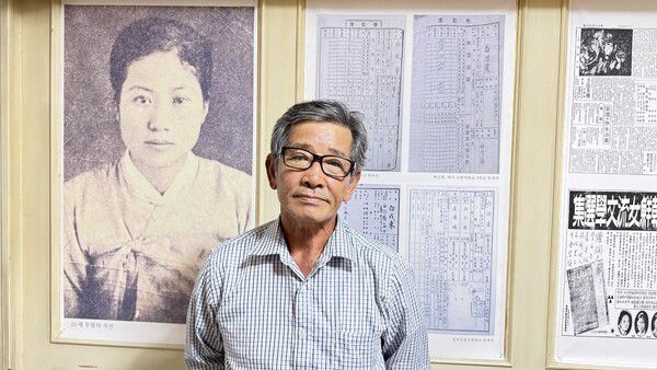 이중기 시인이 백신애 작가 사진을 배경으로 사진을 찍고 있다. 강성만 선임기자