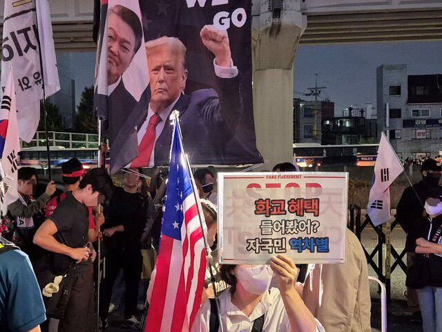 민초결사대 등 극단적 보수 성향 단체 관계자들이 25일 저녁 서울 영등포구 대림역 4번 출구 앞에서 연 반중 시위 참가자가 ‘화교 혜택 들어봤어? 자국민 역차별’이라고 적은 손팻말을 들고 있다. 정인선 기자