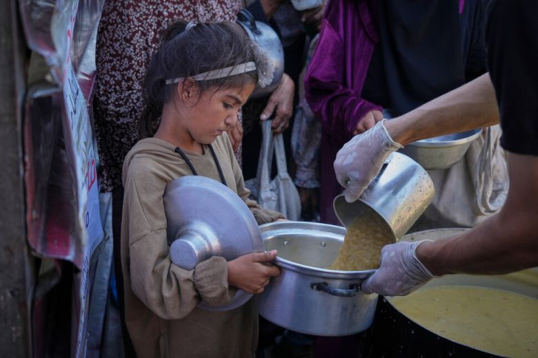 27일 가자지구 남부 칸 유니스의 한 공공 급식소에서 한 소녀가 구호 음식을 배급받고 있다. AP연합뉴스