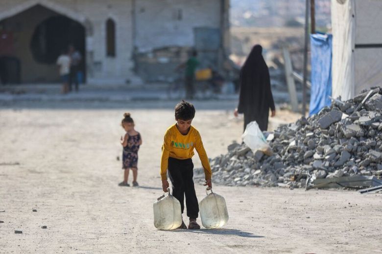 24일 가자지구 남부 칸유니스의 임시 이주민 거주 지역에서 한 소년이 물을 들고 걸어가고 있다. 최근 이스라엘 군은 가자시 중심부에서 하마스 전투원들을 제거하겠다며 가자지구에 대한 대규모 공중 및 지상 공격을 감행해왔다. AFP연합뉴스