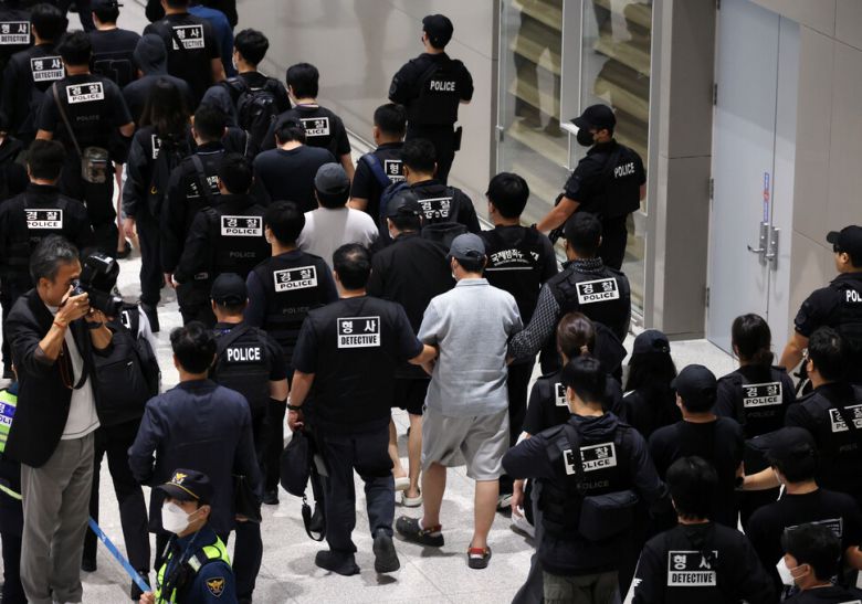 캄보디아에서 보이스피싱(전화금융사기) 등 범죄에 가담했다가 현지 경찰 조사를 받고 이민 당국에 구금됐던 한국인 64명이 18일 오전 인천국제공항 제2터미널을 통해 송환되고 있다. 공동취재사진