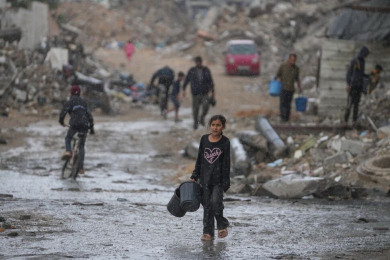 14일(현지시각) 가자지구 가자시티에 폭우가 쏟아지는 가운데 한 팔레스타인 소녀가 물을 긷기 위해 빈 물통을 들고 걷고 있다. 폭우로 난민 캠프의 천막들이 물에 잠겨 팔레스타인 주민들이 고통을 호소하고 있다. AP 연합뉴스